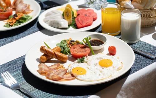 een bord met ontbijtproducten met eieren en spek bij Siem Reap Urban Boutique Hotel in Siem Reap