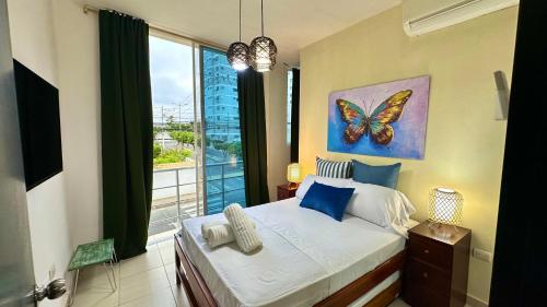 a bedroom with a bed with a butterfly painting on the wall at DEPARTAMENTOS, a una calle de la PLAYA Y MALECÓN in Salinas
