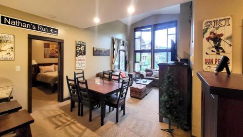 a dining room and living room with a table and chairs at Stones Throw #38 By Bear Country in Sun Peaks