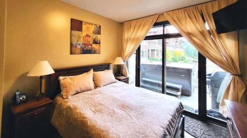 a bedroom with a bed and a large window at Stones Throw #38 By Bear Country in Sun Peaks