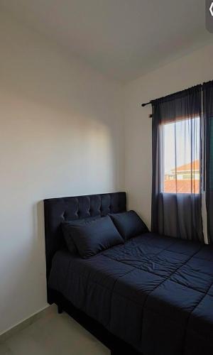 ein Schlafzimmer mit einem blauen Bett und einem Fenster in der Unterkunft Casa completa em Praia Grande, 500 metros da praia in Praia Grande