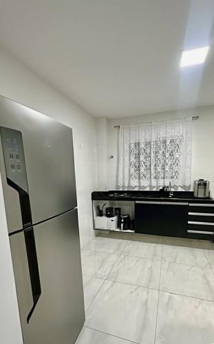 eine Küche mit einem Kühlschrank mitten im Raum in der Unterkunft Casa completa em Praia Grande, 500 metros da praia in Praia Grande