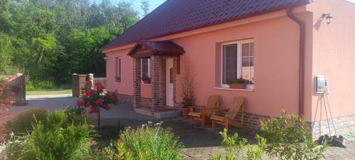 a small pink house with a bench and a window at Dovolenkový dom na juhu Slovenska in Jahodná