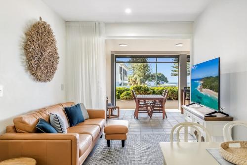 a living room with a couch and a table at Sea Esta - Lennox Head in Lennox Head