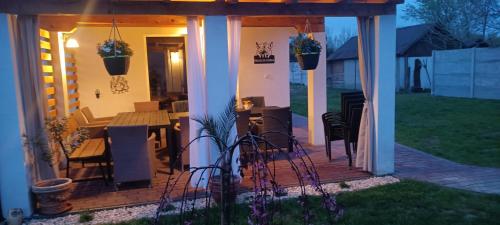 a pergola with a table and chairs on a patio at Dovolenkový dom na juhu Slovenska in Jahodná