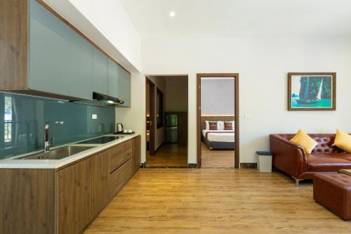 a kitchen with a sink and a couch at Viet Hoa Hotel & Residence Cat Ba - Rooftop Pool in Cat Ba