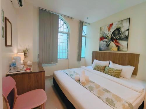 a bedroom with a large bed and a chair at SCC Hotel Chinatown in Kuala Lumpur