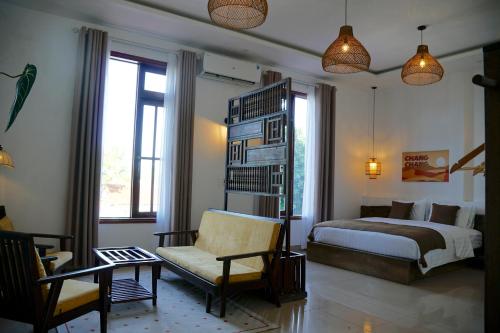 a bedroom with a bed and a chair at Chang Chang Cozy Home in Kon Rung (1)