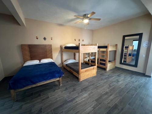 Un dormitorio con una cama y un ventilador de techo. en La Casa del Mercado, en San Miguel de Allende