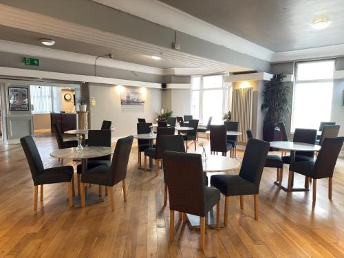 a restaurant with tables and chairs in a room at Lord Nelson Hotel-Lime Street Station Liverpool by Compass Hospitality in Liverpool