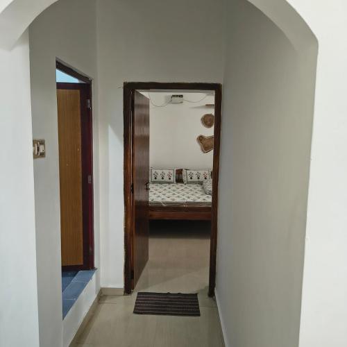 - un couloir avec un miroir et un lit dans une chambre dans l'établissement Thamara Auroville Homestay, à Pondichéry