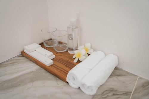 a wooden table with glasses and flowers on it at Cavahills Cottage in Denpasar