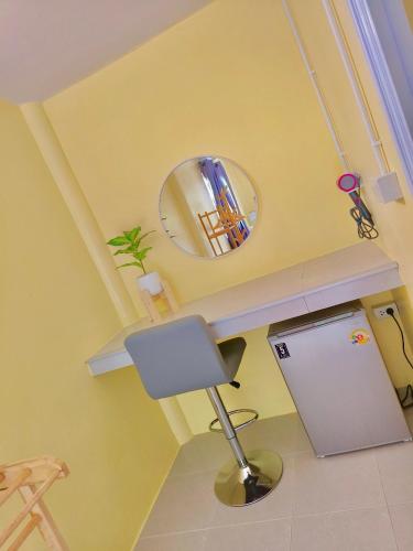 a yellow room with a chair and a mirror at Ari homestay in Ko Kood