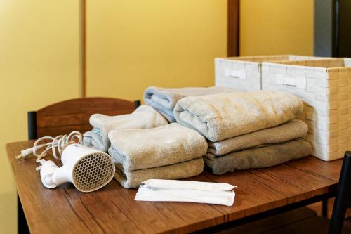 ein Haufen Handtücher auf einem Holztisch in der Unterkunft 5 minutes on foot from the station, 20 minutes by train to Nagoya station, and it is a detached house, so families can use it with peace of mind! in Nagoya