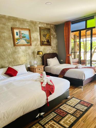 a hotel room with three beds and a window at Huen San Fang hotel โรงแรมเฮือนแสนฝาง in Fang