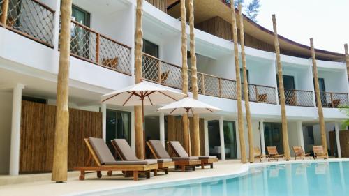 a resort pool with lounge chairs and umbrellas at The TALAY in Ban Na Tai
