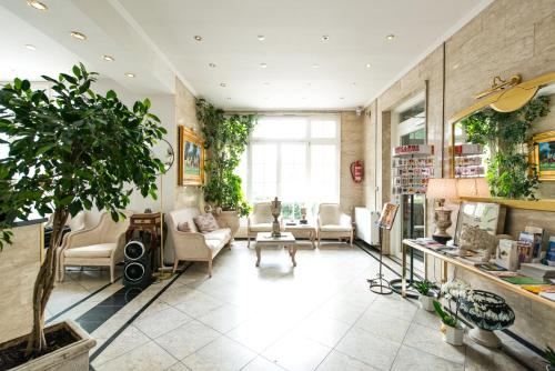 a living room filled with furniture and a potted plant at Löwen Hotel in Offenbach