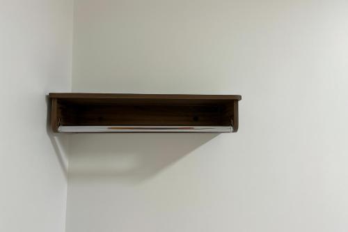 a wooden shelf on a white wall at Nova Jerusalém Hotel in Goiânia