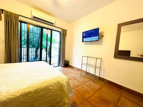 a bedroom with a bed and a mirror and a window at Large family house in Cabo , pet friendly in Cabo San Lucas