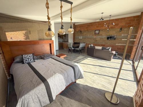 a bedroom with a bed and a living room at Rancho Valsan Cabaña El Tiro in El Oro de Hidalgo