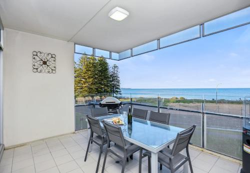 a dining room with a view of the ocean at Frontage Apartments- 3Bedroom Central Seaview Escape in Victor Harbor