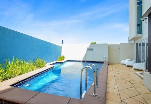 a swimming pool on the side of a building at Frontage Apartments- 3Bedroom Central Seaview Escape in Victor Harbor