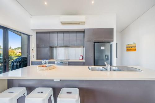 eine Küche mit Spüle und Arbeitsfläche sowie drei Toiletten in der Unterkunft Sandy Feet in Lennox Head