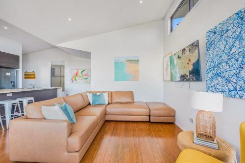 a living room with a couch and a kitchen at Sandy Feet in Lennox Head