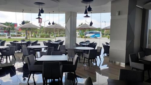 a restaurant with tables and chairs and a parking lot at Wing Hotel Kualanamu Airport in Kampungbesar