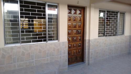 a pair of wooden doors on a building at Casa Matinhos Caioba Parana in Matinhos