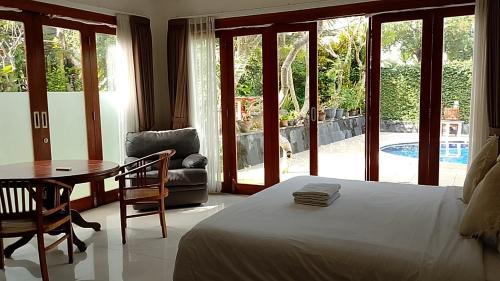 a bedroom with a bed and a table and a chair at casavina studio 304 private kitchen, Near beach in Canggu
