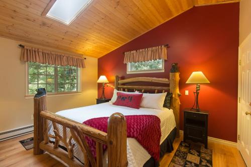 um quarto com uma cama de madeira e paredes vermelhas em A Hidden Haven Cottages em Port Angeles