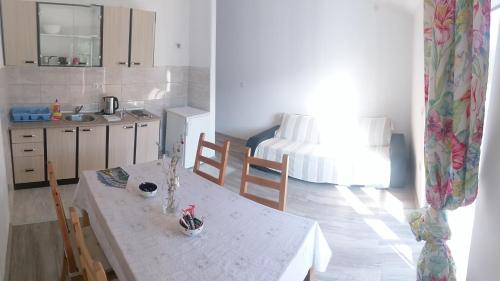 a kitchen with a table and a room with a bed at Apartments Sadina in Skradin