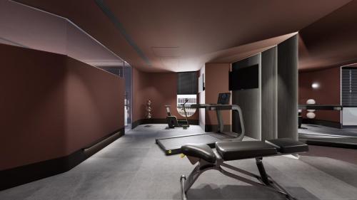 einen Fitnessraum mit einem Laufband und einem Stuhl in einem Zimmer in der Unterkunft SUPERB HoTEL in Magong