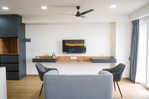 una sala de estar con una mesa y sillas en Cozmo Studio, Next to Pune Airport, en Pune