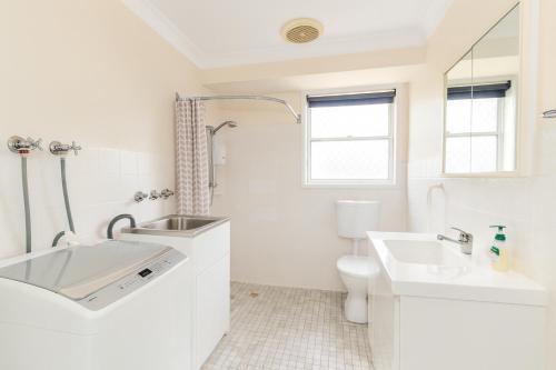 um banheiro branco com uma pia e um vaso sanitário em Brook Village em Muswellbrook