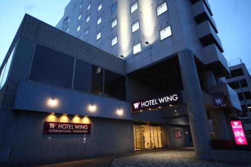 a building with a hotel winning sign in front of it at Hotel Wing International Tomakomai in Tomakomai