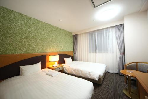 Habitación de hotel con 2 camas y ventana en Hotel Wing International Tomakomai en Tomakomai