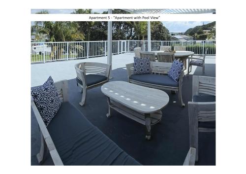 a porch with chairs and a table and a table and chairs at Stay n Play n Russell in Russell