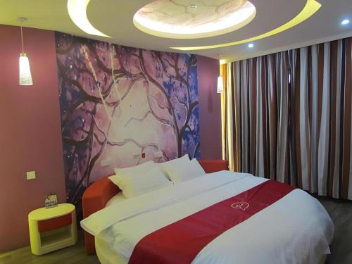 une chambre avec un grand lit avec un tableau au mur dans l'établissement Thank Inn Hotel Hebei Xingtai Shaheweisan Road Expressway Intersection, à Shahecheng