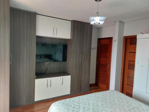 a bedroom with a bed and a tv and white cabinets at Cobertura COP30 in Belém