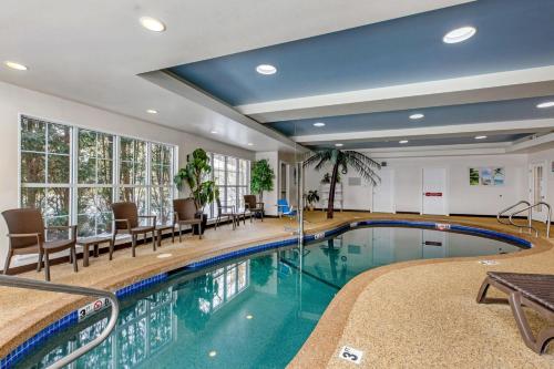a swimming pool in a hotel with chairs and tables at Comfort Inn & Suites North Conway in North Conway