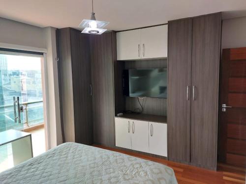 a bedroom with a bed and a tv and cabinets at Cobertura COP30 in Belém