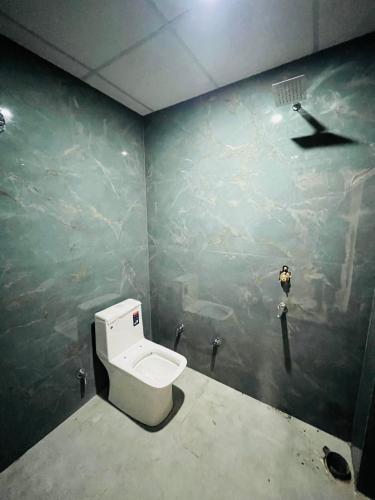 a bathroom with a white toilet in a room at Hotel KT palace in Mirza Murād