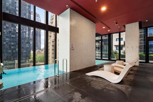 a lobby with a swimming pool and a building at Home in the Sky 2BR Apt with City and River View in Melbourne