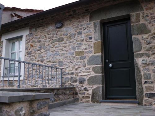 a black door on the side of a stone building at Casa Natale in Corvara