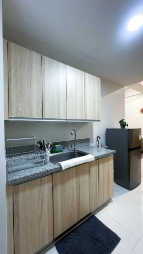a kitchen with a sink and a refrigerator at WV 30 Bright 2BR Escape in Sampong