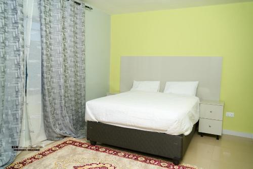 a bedroom with a bed and a large window at K&M Luxury Apartments Solwezi in Solwezi