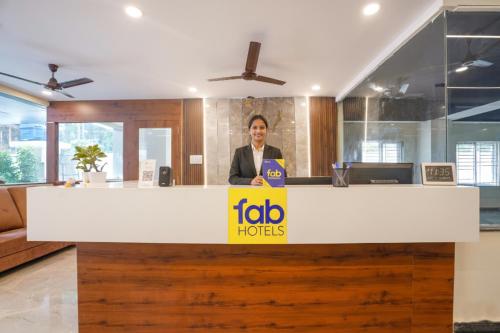 ハイデラバードにあるFabHotel Air Live - Nr Ameerpet metro stationのオフィスの受付カウンターの後ろに立っている女性
