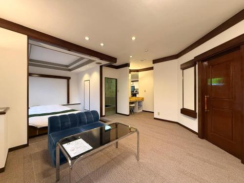 a room with a bed and a couch and a table at ジーアール柳井 in Yanai